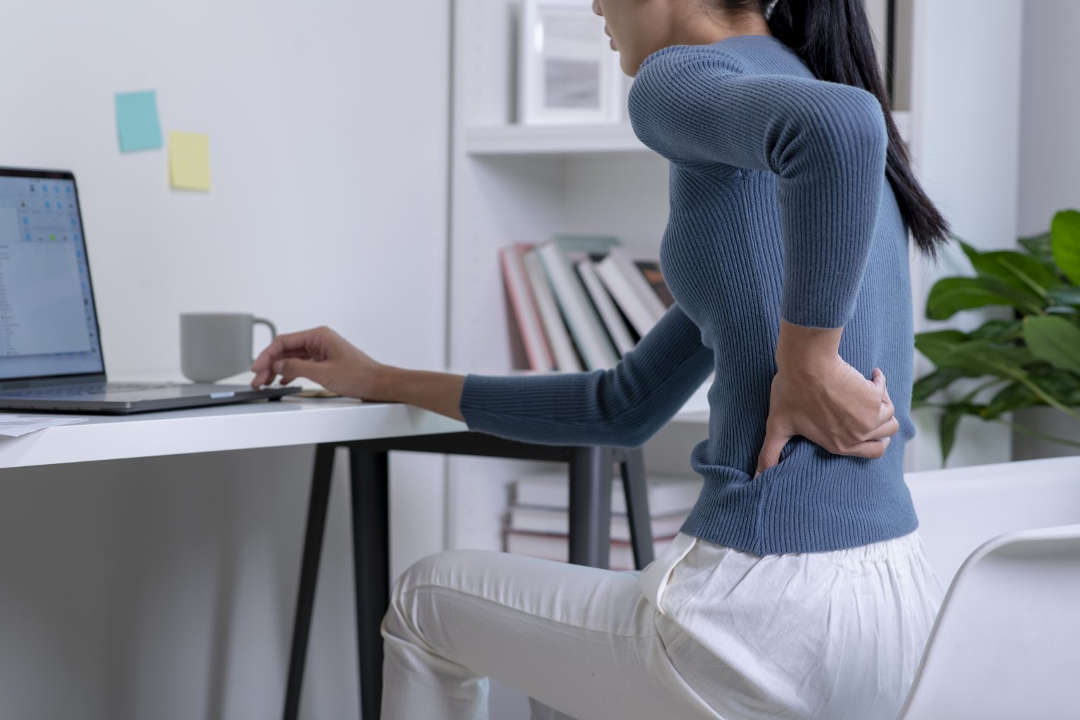 Persona trabajando sentada con dolor lumbar y realizando una pausa de movimiento